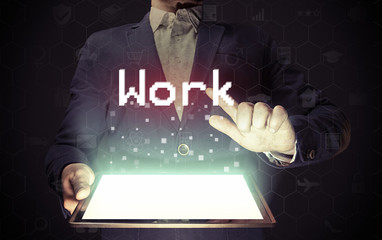 Image of a man with a tablet in his hands. His hand touches the "work" button. Online work search concept.