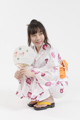 しゃがんで笑顔の浴衣姿の女の子