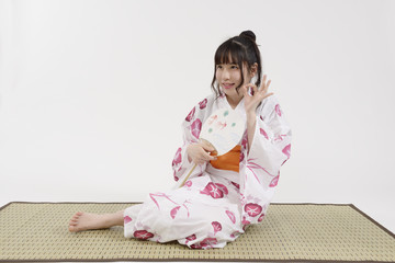 畳に座る浴衣姿の女性