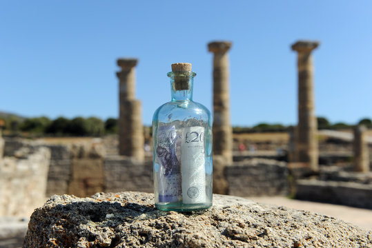 Billete de veinte libras esterlinas en unas ruinas romanas, conceptp del negocio del turismo