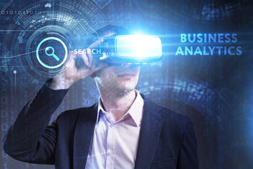 Business, Technology, Internet and network concept. Young businessman working in virtual reality glasses sees the inscription: Business analytics