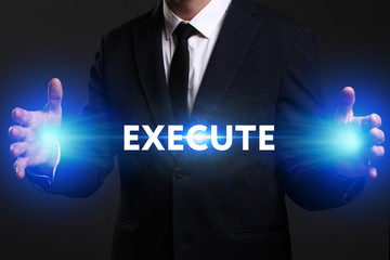 Business, Technology, Internet and network concept. Young businessman working on a virtual screen of the future and sees the inscription: Execute