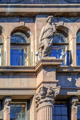 Marble woman statue on the facade of an old building. St. Petersburg, Russia