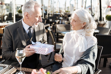 Enigmatical gentleman holding gift box