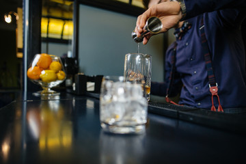 Bartender is making cocktail at bar.