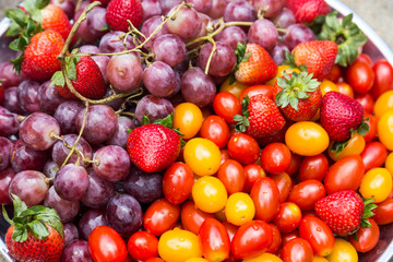Close-up on fresh and sweet organic grapes, strawberries, cherry tomatoes
