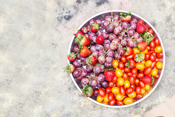 Tray of fresh and sweet organic grapes, strawberries, cherry tomatoes