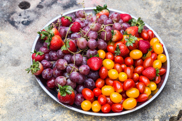 Tray of fresh and sweet organic grapes, strawberries, cherry tomatoes