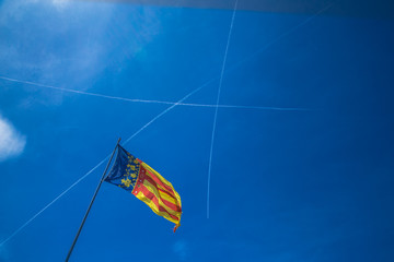 Catalonia flag in Valencia, Spain on the blue sky background