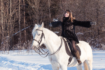 Fototapeta na wymiar Nice girl and white horse in a forest in a winter
