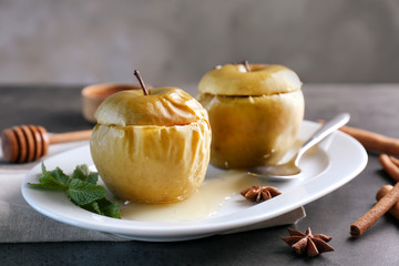 Plate with tasty baked apples on table, closeup
