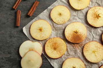 Composition with fresh cut apples and cinnamon prepared for making chips, on grey table