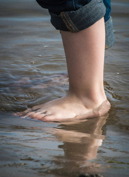 kid's foot in river with reflection
