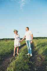 beautiful pregnant girl and her husband in the nature