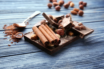 Dark chocolate pieces with cinnamon on wooden table