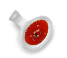 Tasty chili sauce in bowl on white background