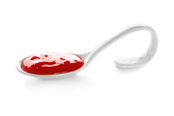 Tasty chili sauce in spoon on white background