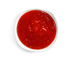 Tasty chili sauce in bowl on white background