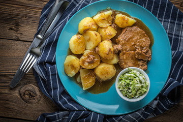 Braised meat in sauce served with boiled potatoes.