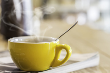 Yellow mug on magazine in cafe