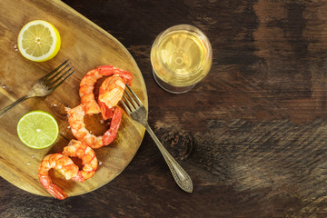 Glass of white wine with cooked shrimps and copyspace