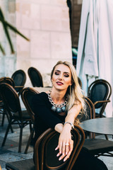 portrait of smiling blonde sitting at a table in cafe
