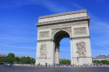 Fototapeta na wymiar Arc de Triomphe popular top attraction in city of Paris, France. View from Champs Elysees street to Place Charles de Gaulle. Beautiful summer scene blue sky background.