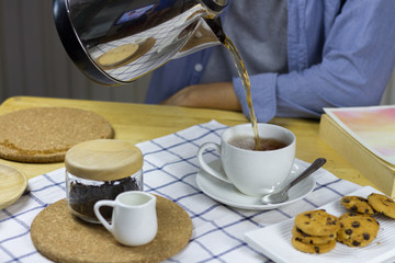 Man Pouring tea in house.
