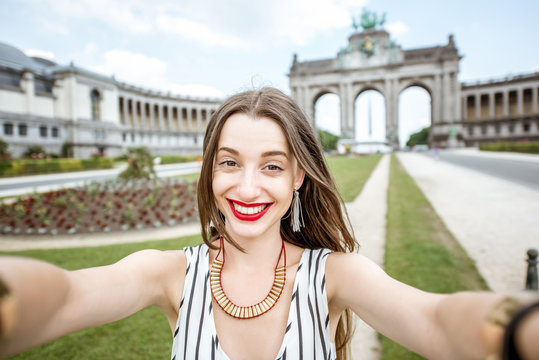 Young female traveler making selfie photo on the famous Triumphal arch background in Brussels