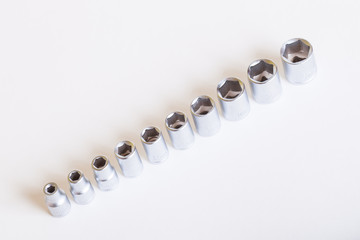 A set of heads for the car on a light background. Metal adapter under the nut.