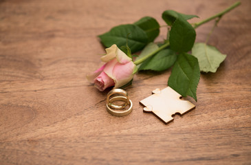 Eheringe mit Rose und Holzintergrund