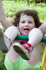 Fototapeta na wymiar Young girl having fun on a swing