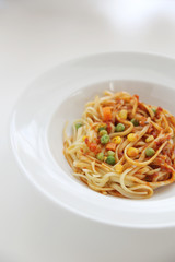 Fettuccine pasta in tomato sauce isolated in white background