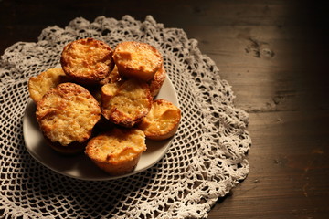 Plate with beautiful muffins on a dark background.