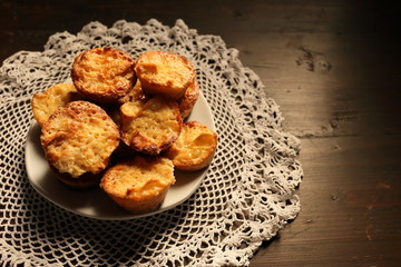 Plate with beautiful muffins on a dark background.