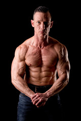 Fototapeta premium fit muscular man posing isolated on a dark background