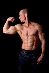Fototapeta premium fit muscular man posing isolated on a dark background