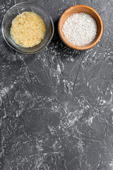 homemade paella ingredients composition with rice in bowl on dark table background top view mock-up
