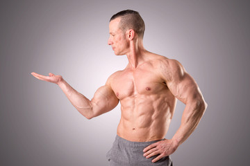 fit muscular man posing isolated on a grey background