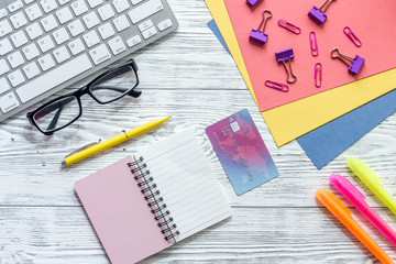Money for education concept. Credit card, notebook, glasses and keyboard on wooden table top view