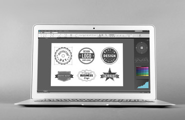Laptop and interface of program for graphic design on screen, gray background. Modern technology...