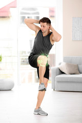 Fototapeta premium Handsome man doing bicycle crunch at home