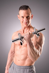 Fototapeta na wymiar fit muscular man posing isolated on a grey background