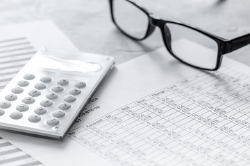 Business report preparing with calculator and glasses on office background