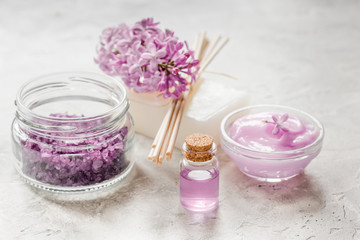 Fototapeta na wymiar lilac natural cosmetic set for spa with salt stone table background