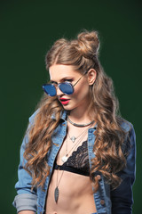 Beautiful stylish woman with sunglasses on color background