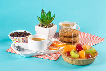 Cake, cups with coffee, cookies on a bright background