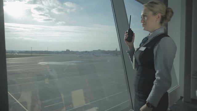The airport worker talks to walkie-talkie