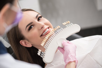 Physician enclosing dental crown to happy lady