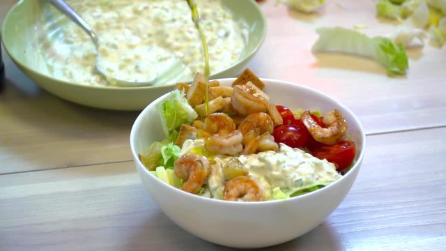 Closeup of tasty fresh salad on the wooden table in the bowl slow motion